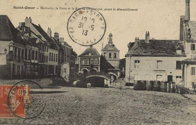 On peut apercevoir dans le fond de la place sur la droite de gros tonneaux et au fond la porte de dunkerque qui donnait sur le Haut-pont.