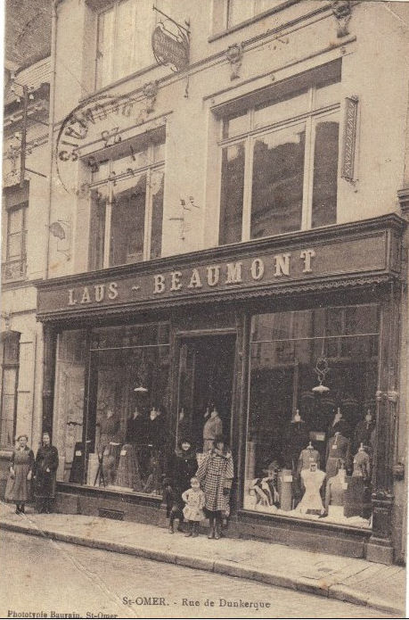 On peut voir sur la carte le magasin de vêtements LAUS-BEAUMONT dans le bas de la rue. Avec des clientes sur le pas de porte.