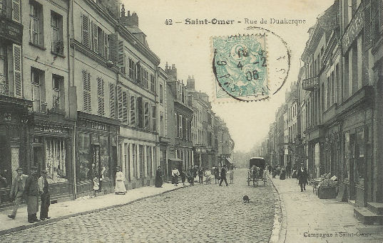 C'est une rue trés commerçante, on voit de chaque côté de monbreux petits commerçes.On se trouve à peu prés au milieu de la rue.