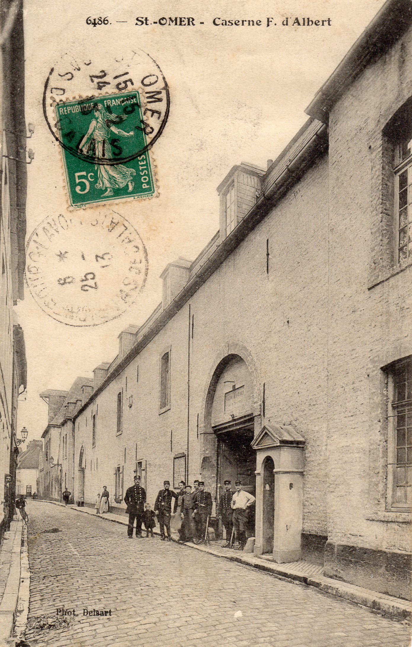 Il y a de nombreux militaires devant l'entrée de la caserne. On voit la guérite à l'entée pour monter la garde.