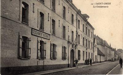 Façade de la caserne de gendarmerie, avec quelques gendarmes devant.