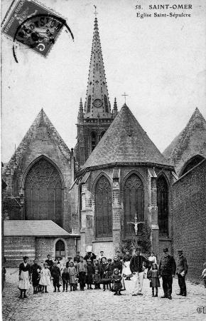 On voit bien les trois nefs qui sont d'une largeur à peu prés égale. Sur la droite de la carte se trouvait la prison de St Omer, on apeçoit le mur d'enceinte. Au premier plan il y a peut être un gardien de la prison en uniforme qui tient la main d'une petite fille ?